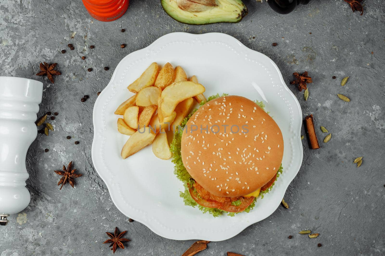 hamburger with fries and salad on the plate.