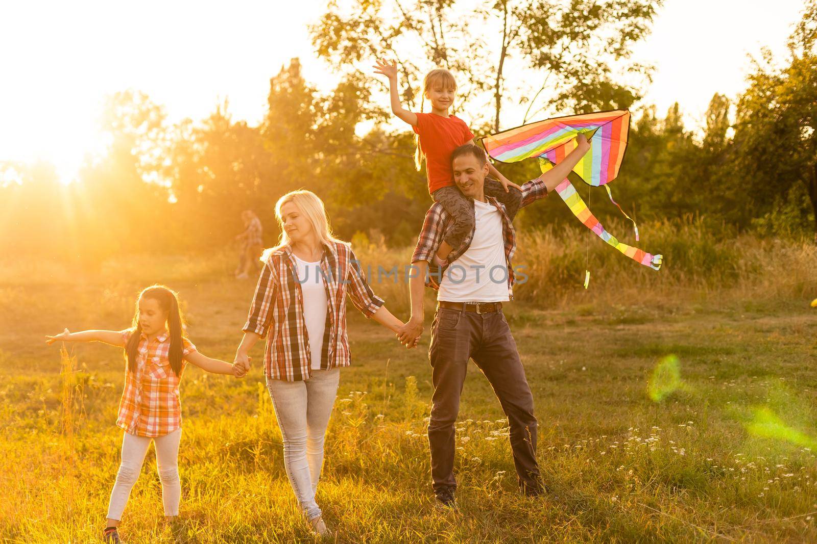 Happy family walking in field and looking at sunset by Andelov13