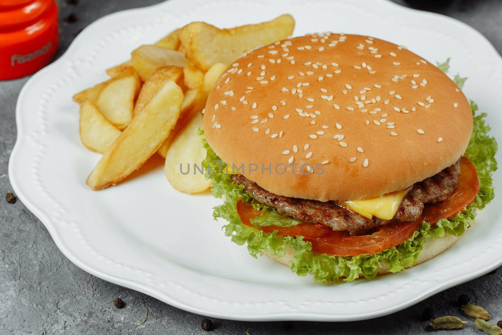 hamburger with fries and salad on the plate.