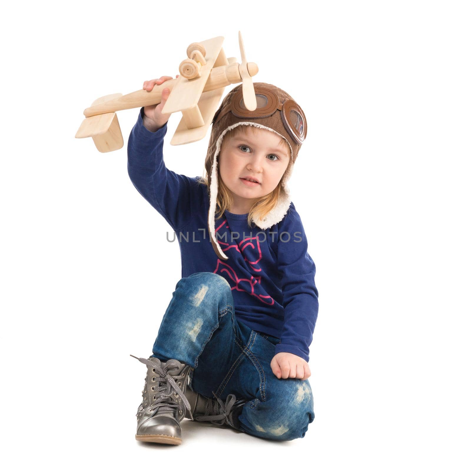 cute little girl in pilot hat with wooden plane by tan4ikk1