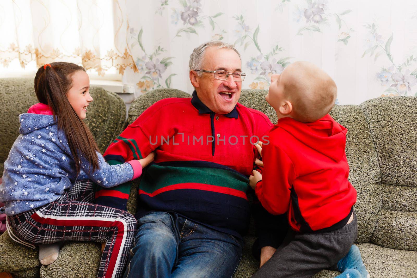 grandfather spends time with grandchildren in the living room by Andelov13