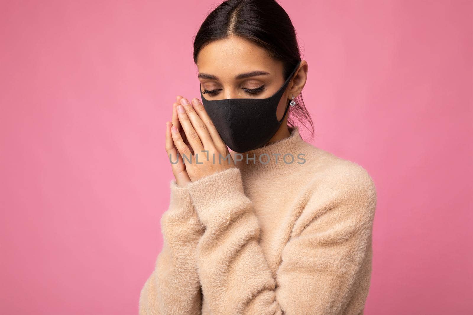 Brunette woman wearing an anti virus protection mask to prevent others from corona COVID-19 and SARS cov 2 infection isolated on pink background.