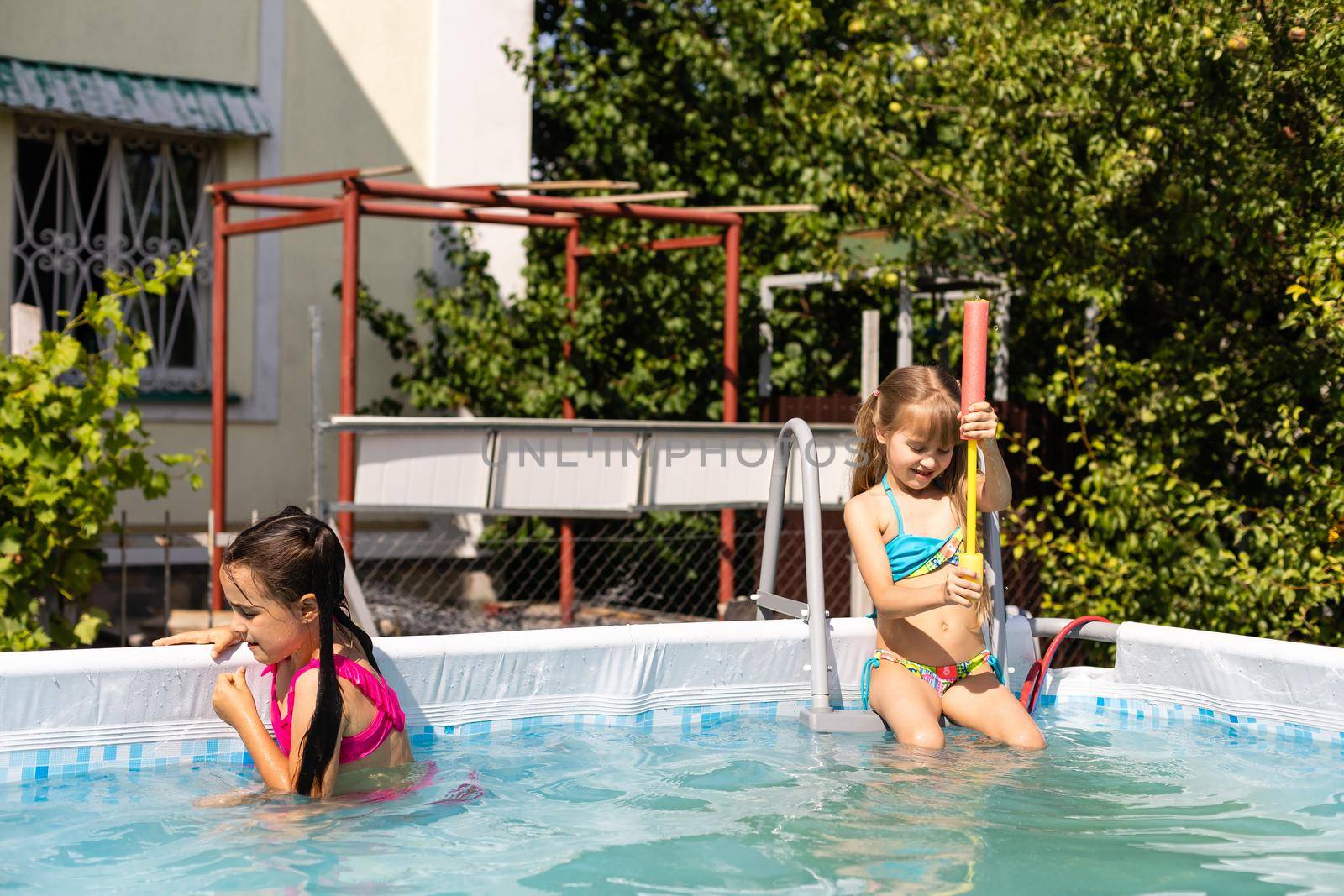 Kids in swimming pool. Girl swim outdoors.