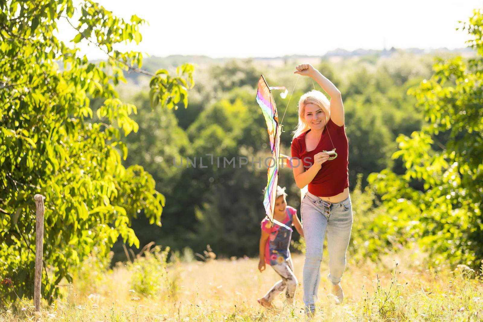 Young woman and girl flying a kite