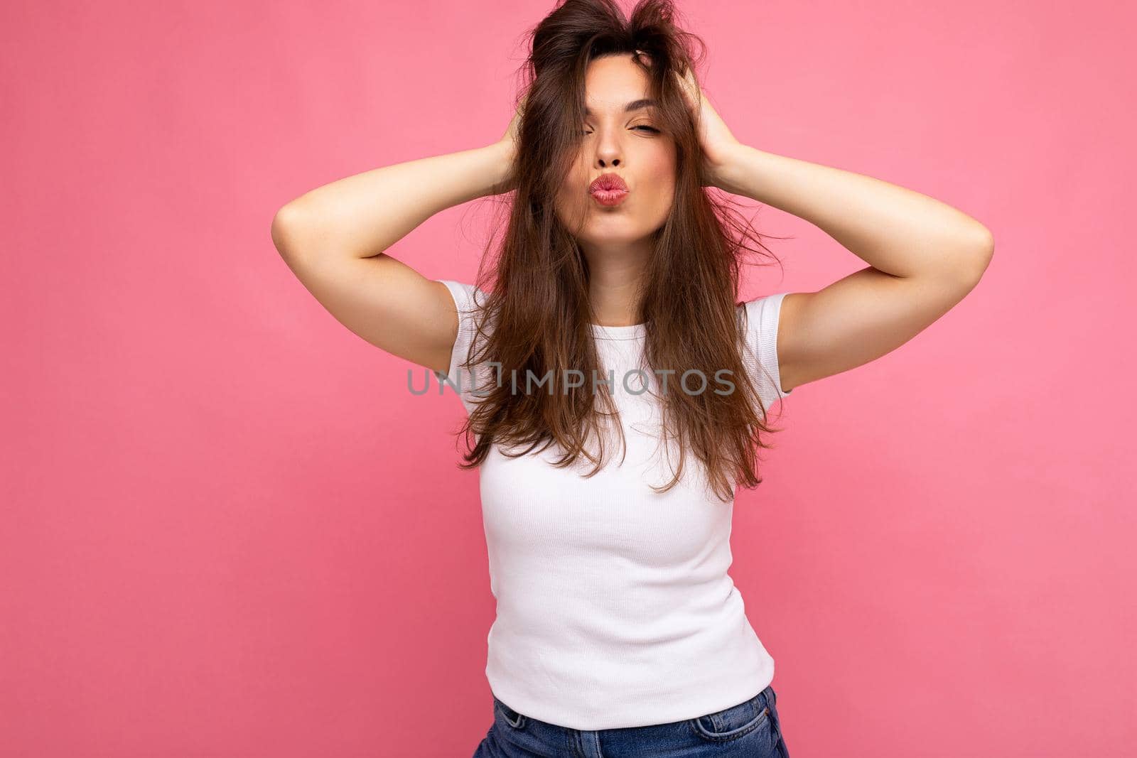Photo shot of cute nice sexy charming gorgeous attractive pretty youngster happy woman wearing white t-shirt for mockup isolated over colorful background with copy space and giving kiss.