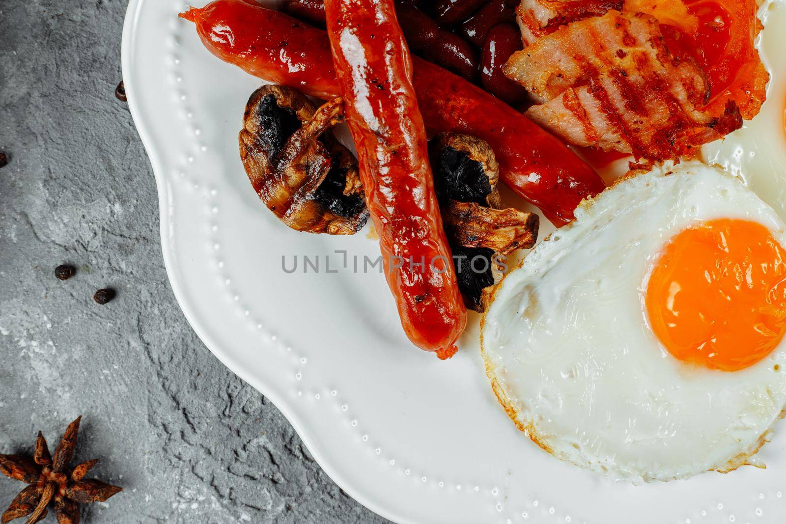 Fried breakfast with bacon, sausages and baked beans.