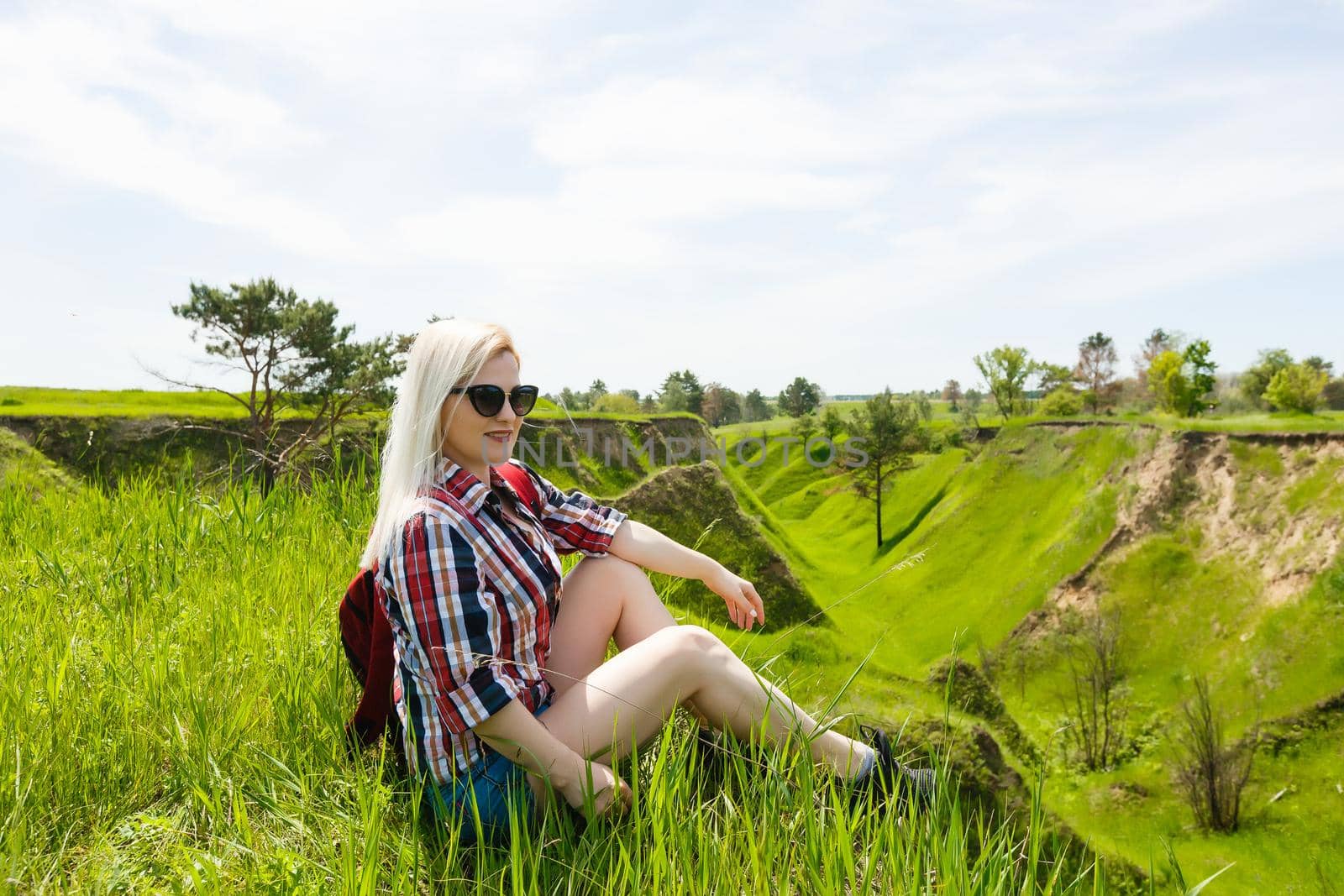 Lifestyle summer image of pretty blonde hipster woman with bag pack traveling and enjoying, stylish fresh look, happy mood, sunny colors, travel concept, emotions.