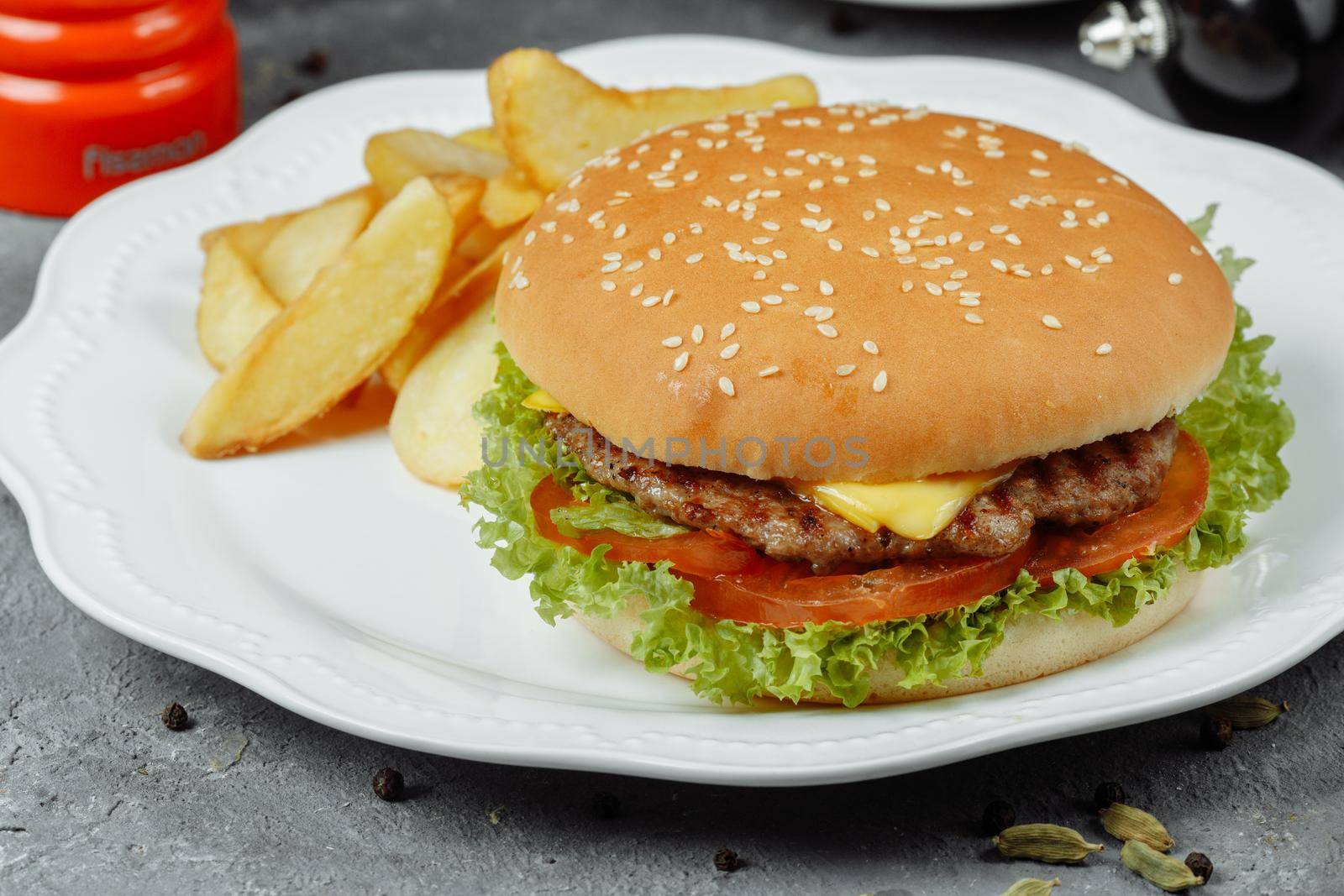 hamburger with fries and salad on the plate.