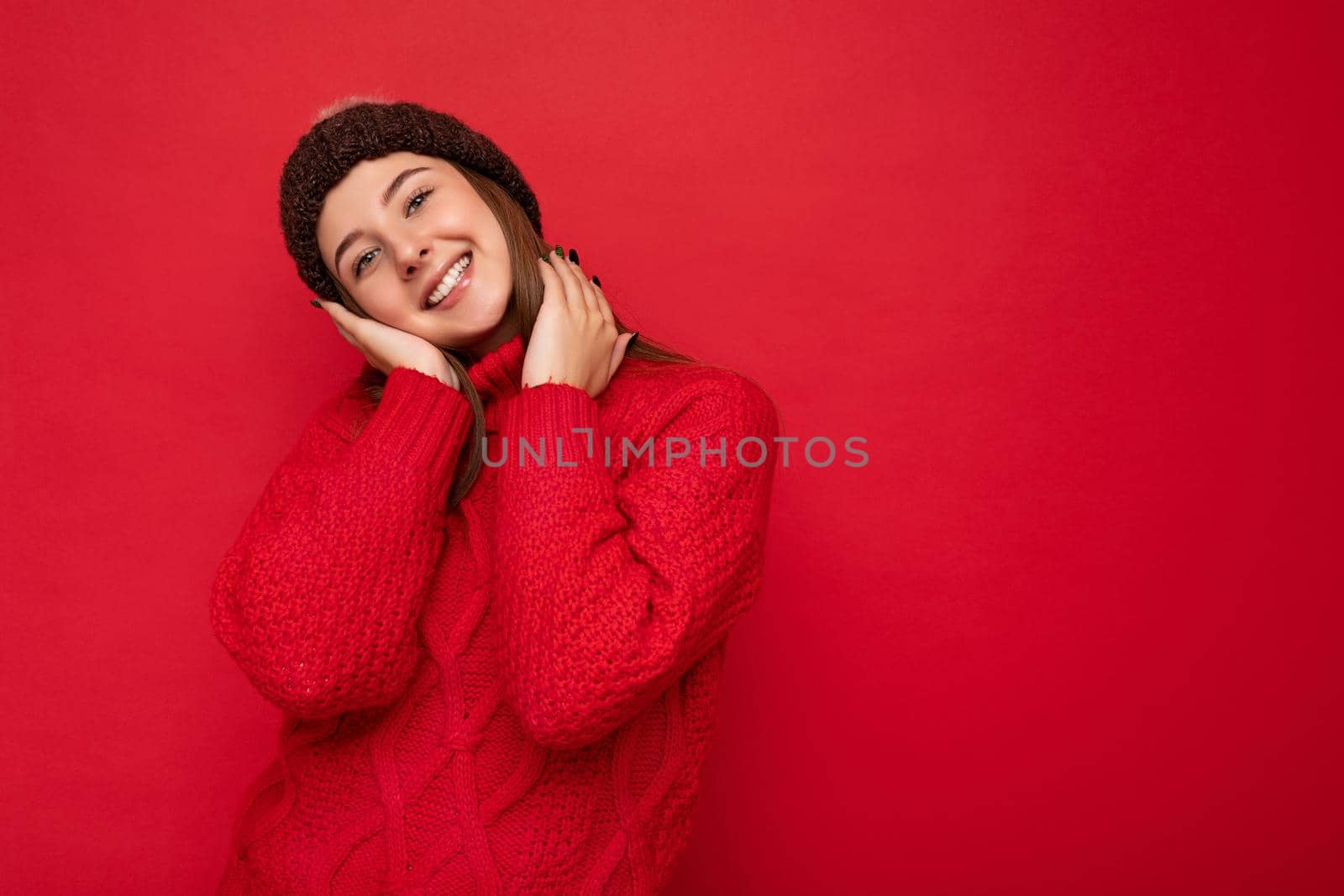 Attractive smiling happy young brunette woman standing isolated over colorful background wall wearing everyday stylish outfit showing facial emotions looking at camera. Empty space