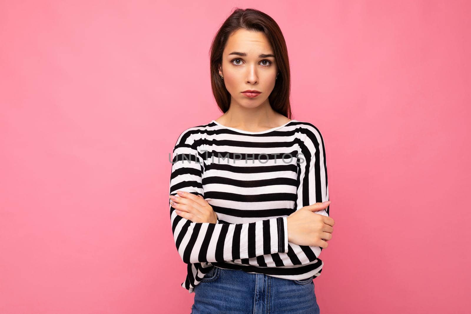 Photo shot of cute attractive pretty young sad upset brunette woman wearing casual striped longsleeve isolated over colorful background with copy space.