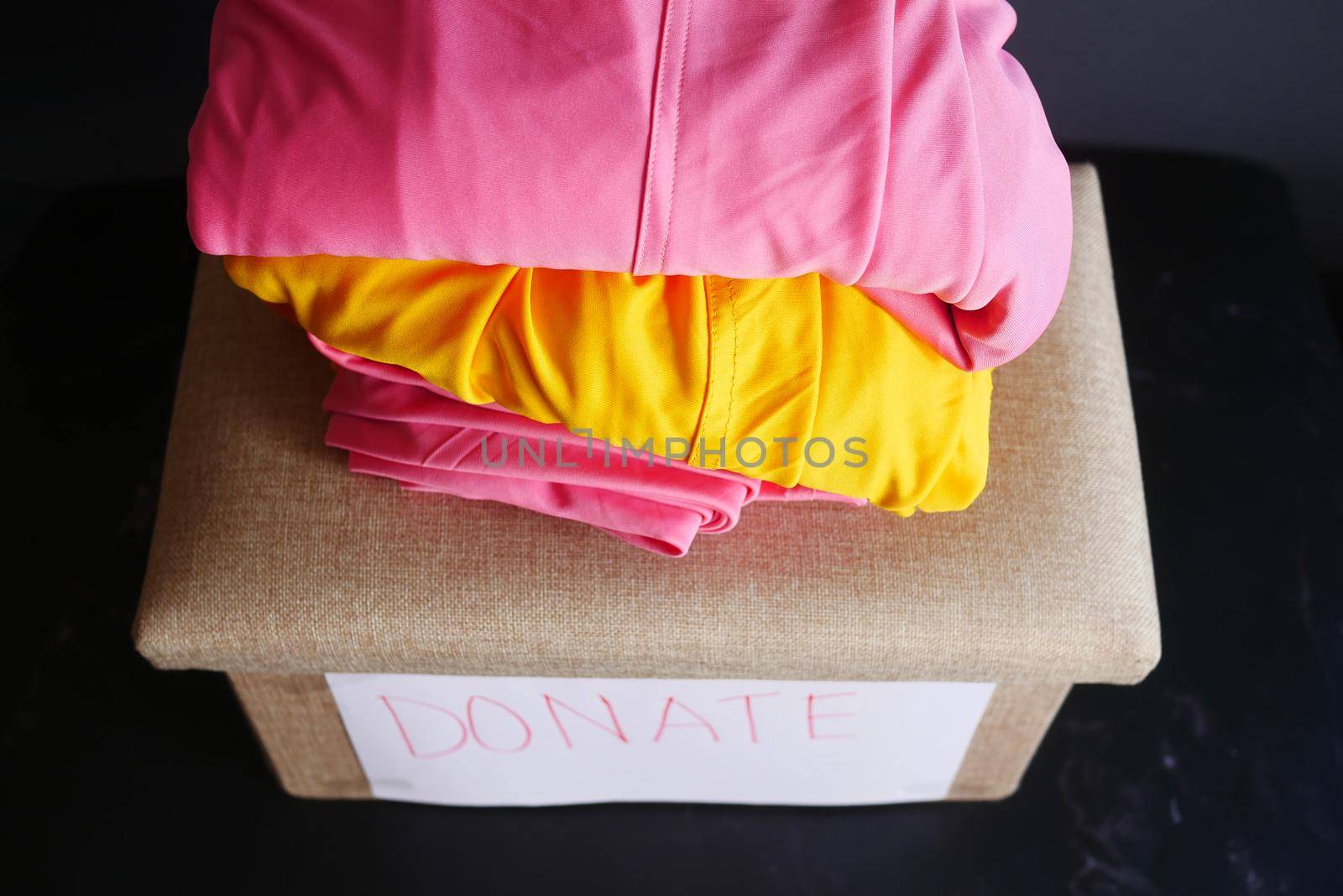 Donation box with donation clothes on a wooden background