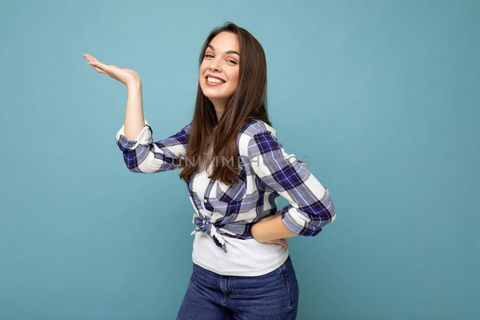 Close up photo of positive happy amazing cute nice charming young woman holding hand and showing advertisement wearing casual clothes isolated over background with copy space.