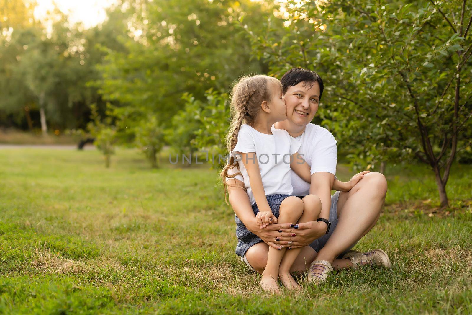 Mother and daughter having fun in the park. Happy family concept. Beauty nature scene with family outdoor lifestyle. Happy family resting together. Happiness and harmony in family life. by Andelov13