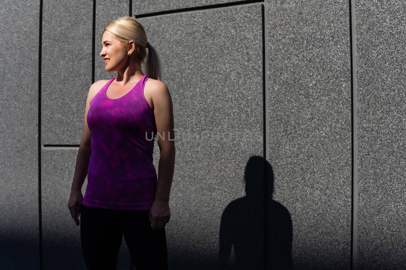 Fitness sport woman in fashion sportswear doing yoga fitness exercise in the street, outdoor sports, urban style