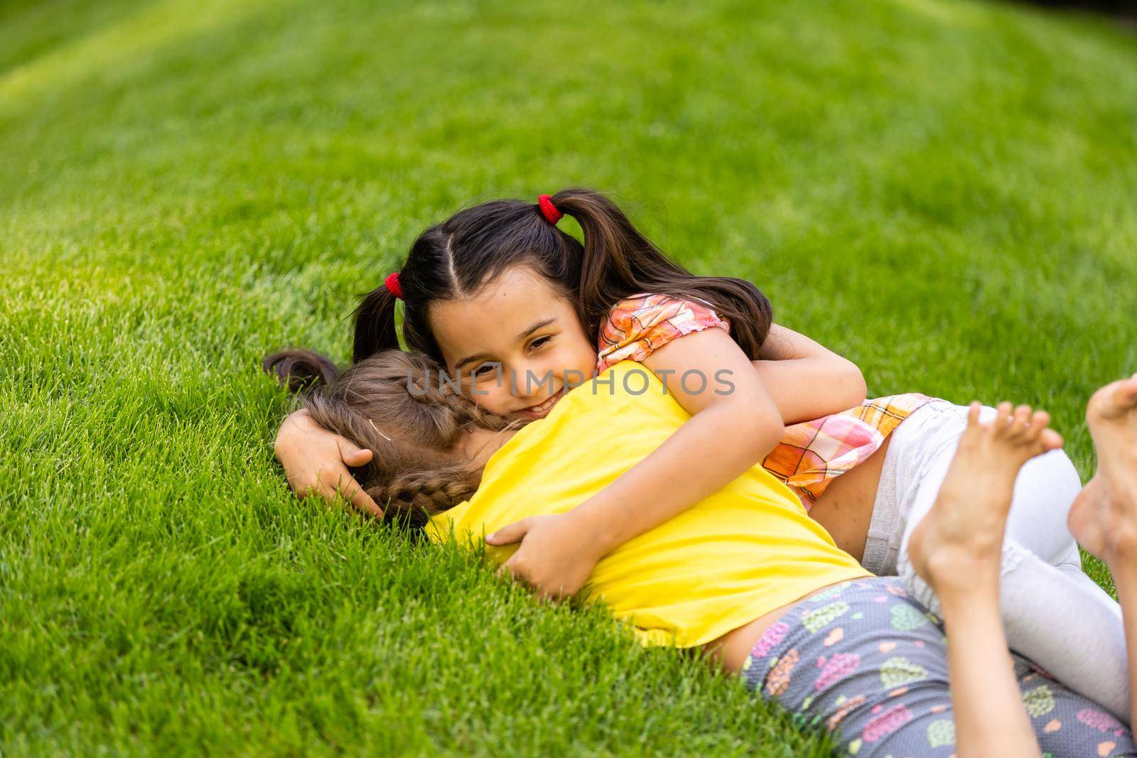 Portrait of two little girls sisters fighting on home backyard. Friends girls having fun. Lifestyle candid family moment of siblings quarreling playing together.