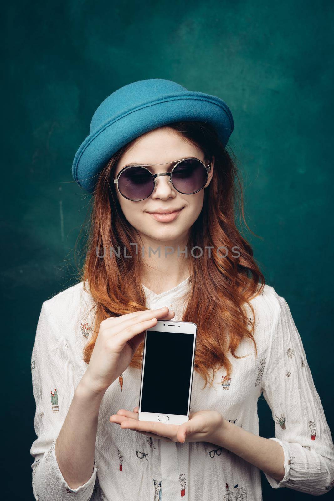 fashionable woman in blue hat with phone in hands communication technology by Vichizh