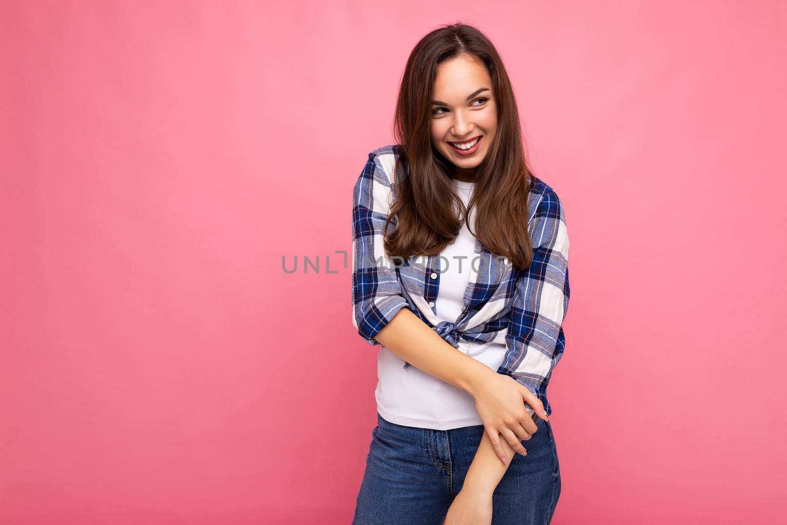 Portrait of positive cheerful fashionable woman in hipster outfit isolated on pink background with copy space.