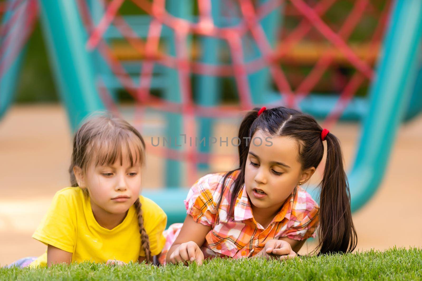 Portrait of two little girls sisters fighting on home backyard. Friends girls having fun. Lifestyle candid family moment of siblings quarreling playing together.