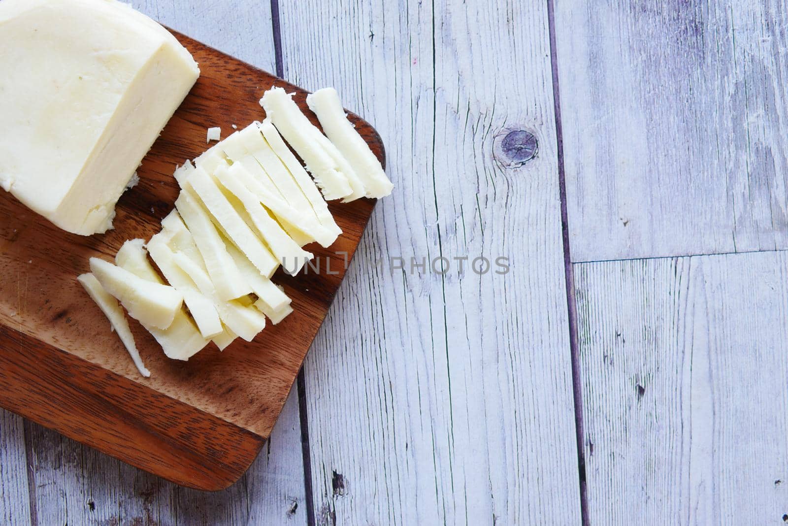 close up of fresh cheese on a chopping board on table .