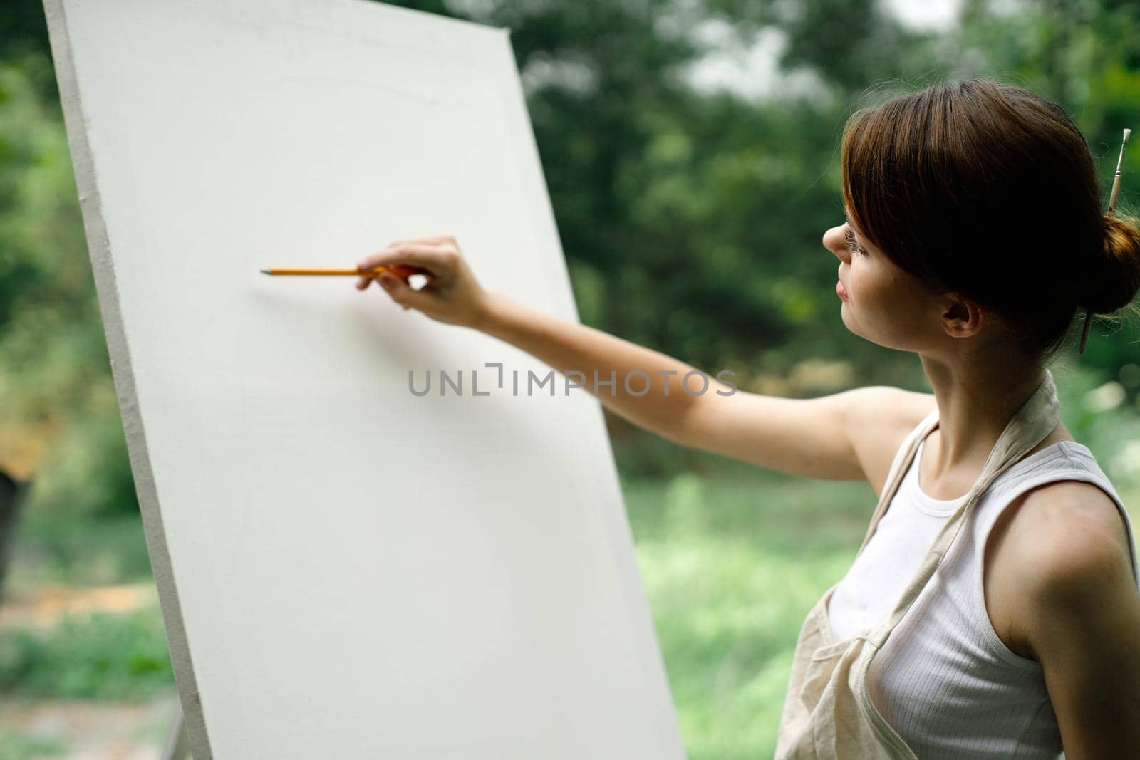 an artist in nature draws on an easel with a pencil. High quality photo