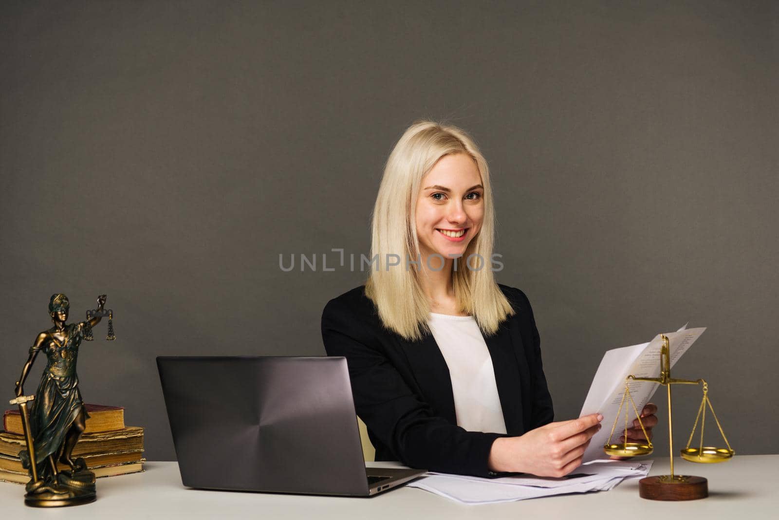Portrait of smiling businesswoman looking at camera and smiling while working at office - image