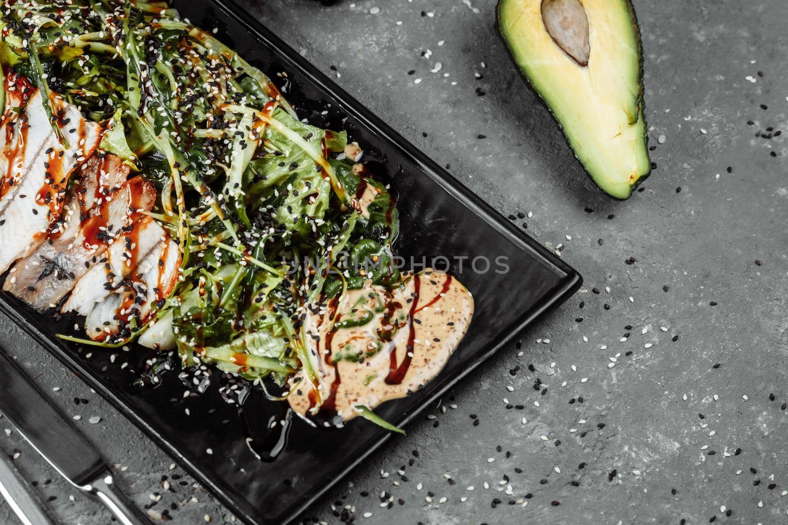 Green salad with smoked eel fish, oranges and avocado slices. Flat lay. Japanese cuisine.