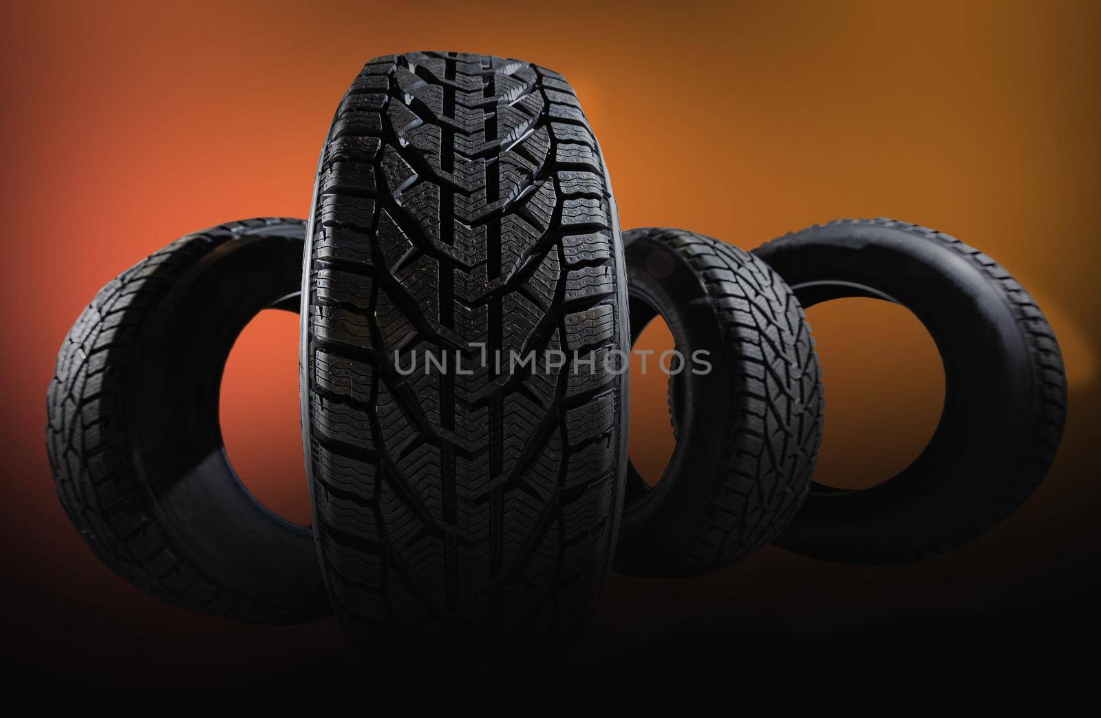 Winter car tires. Group of tires for winter driving on a yellow background. by Andelov13