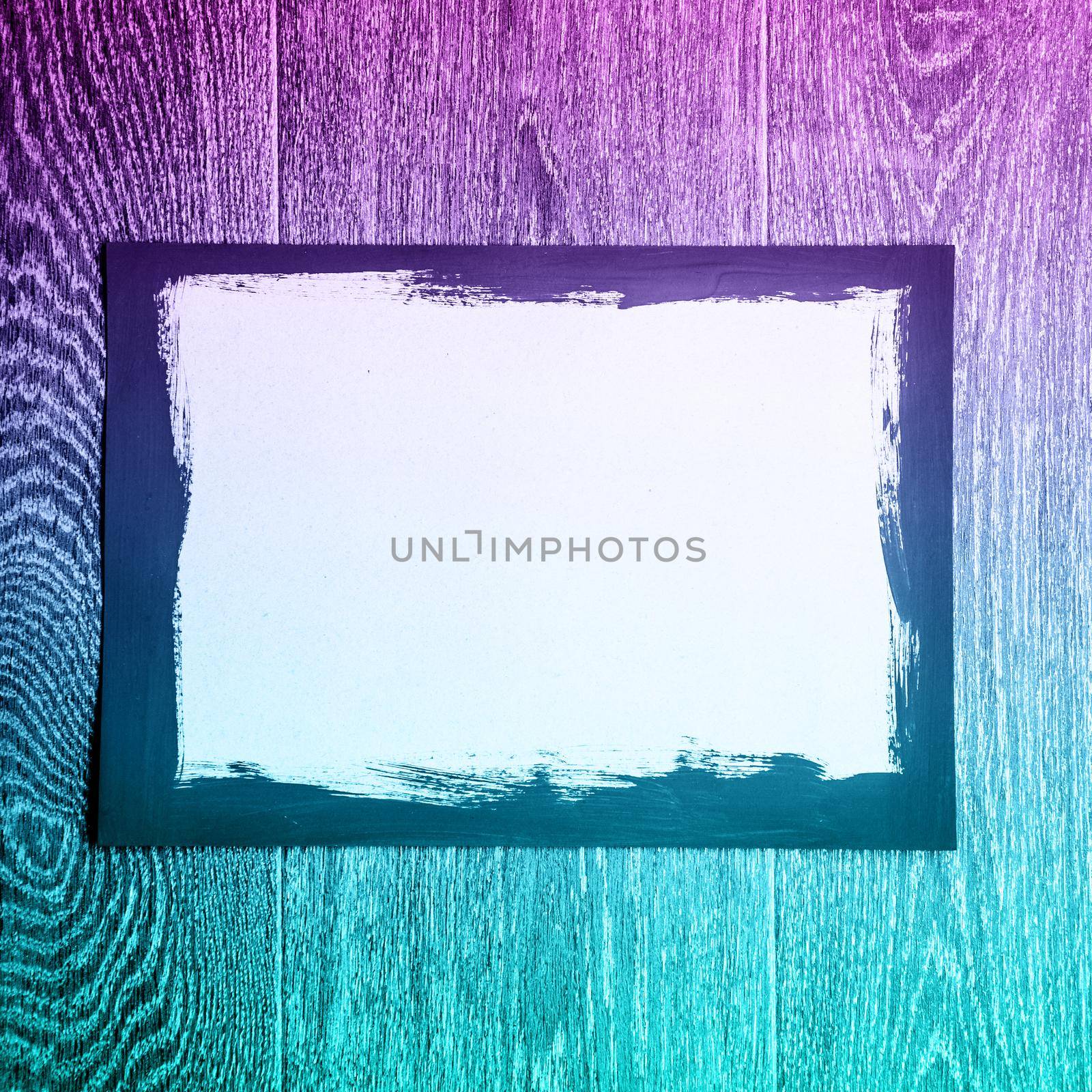 Black painted frame on white paper on wooden background with neon light - image