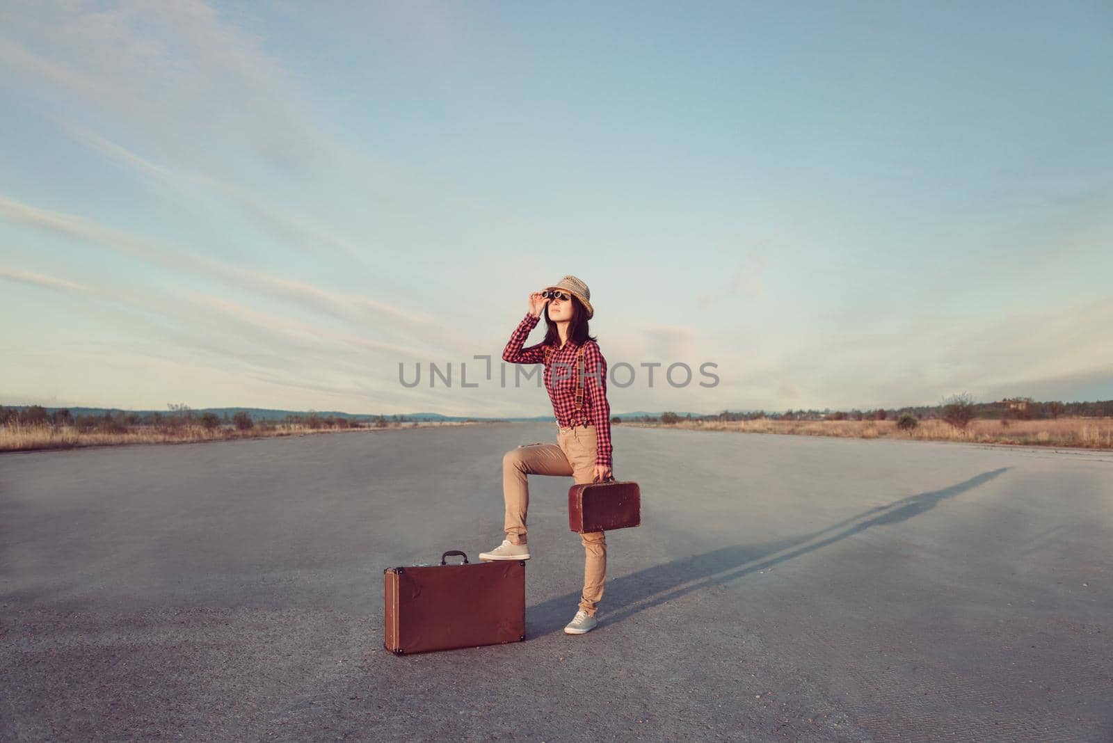 Traveler hipster woman looks through binoculars by alexAleksei