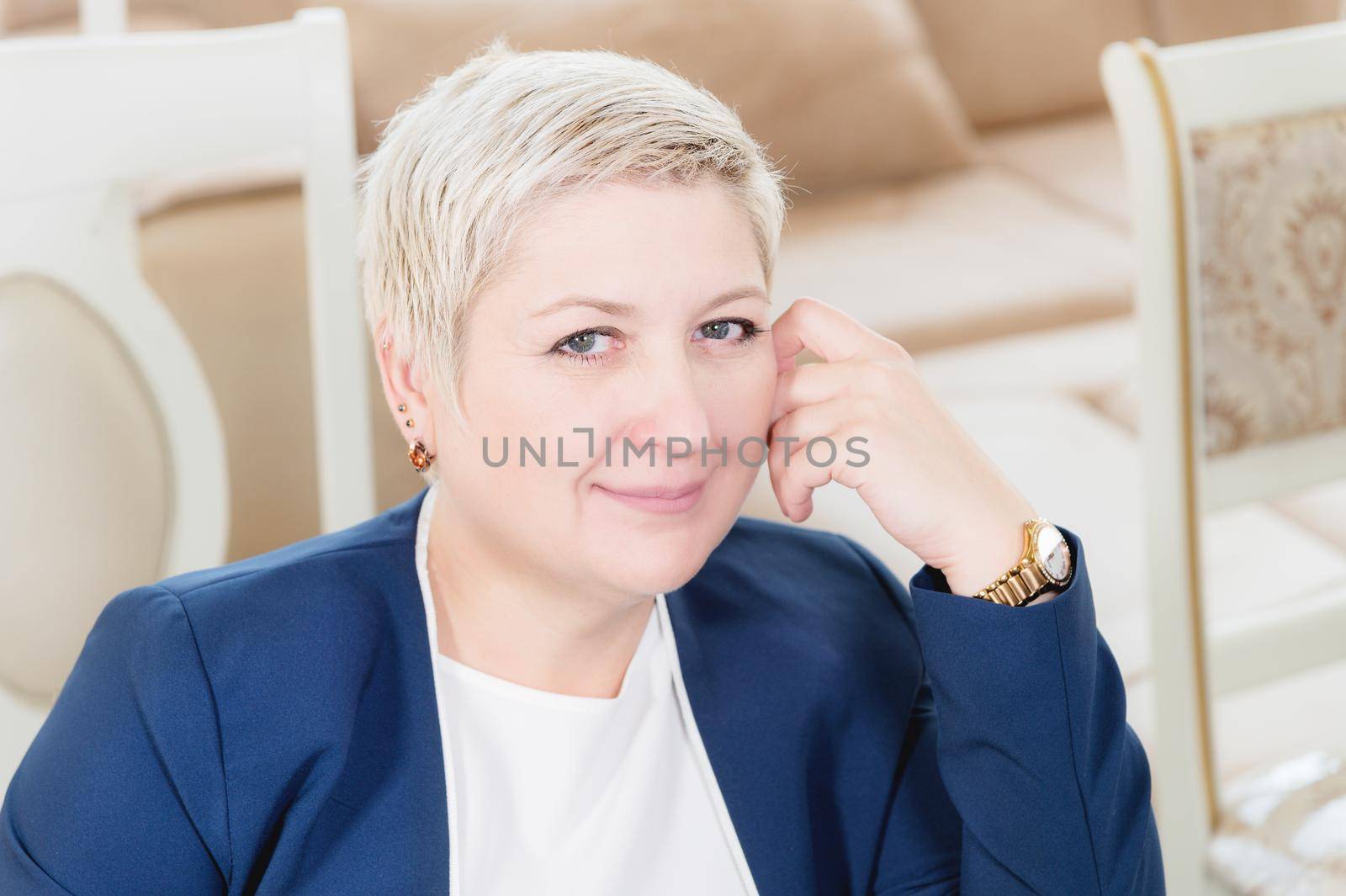 Portrait of a middle-aged woman. The owner and director of the furniture business is sitting in an expensive armchair and smiling. Short-cut strong woman by yanik88