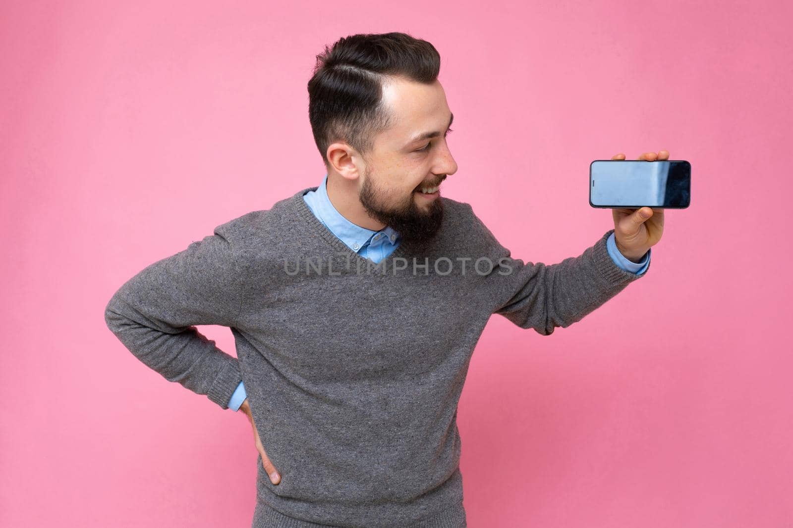Closeup photo of amazing guy holding modern telephone hands casual outfit isolated on bright pink background.