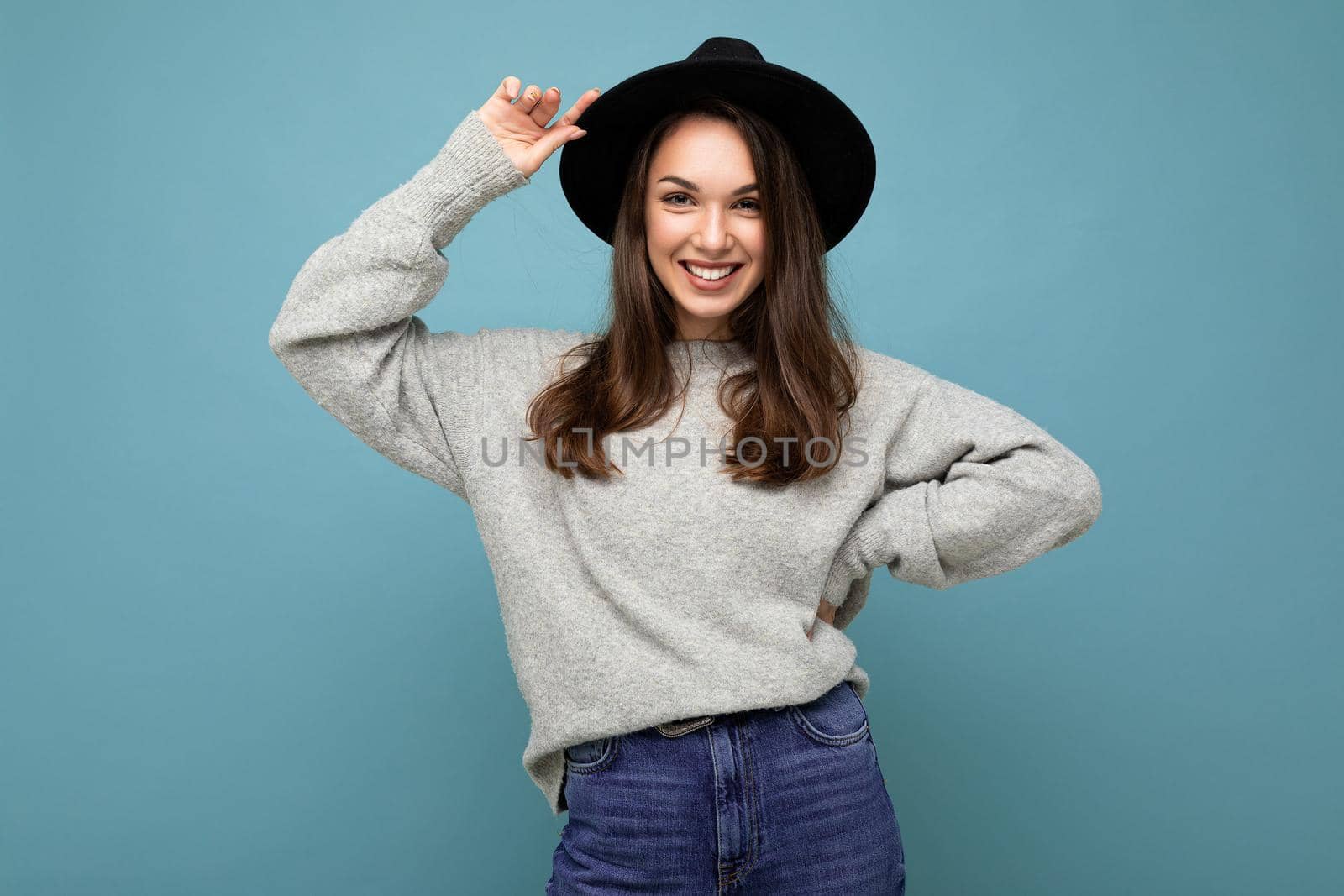Portrait of positive cheerful fashionable woman in stylish clothes isolated on blue background with copy space.