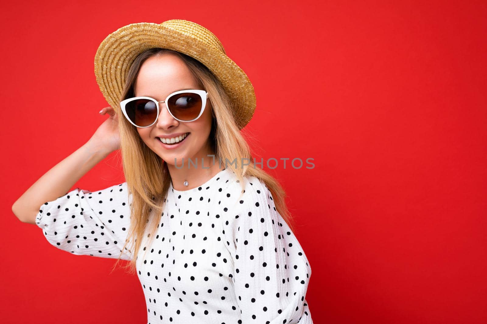 Photo shot of beautiful positive young blonde woman wearing summer casual clothes and stylish sunglasses isolated over colorful background looking at camera by TRMK