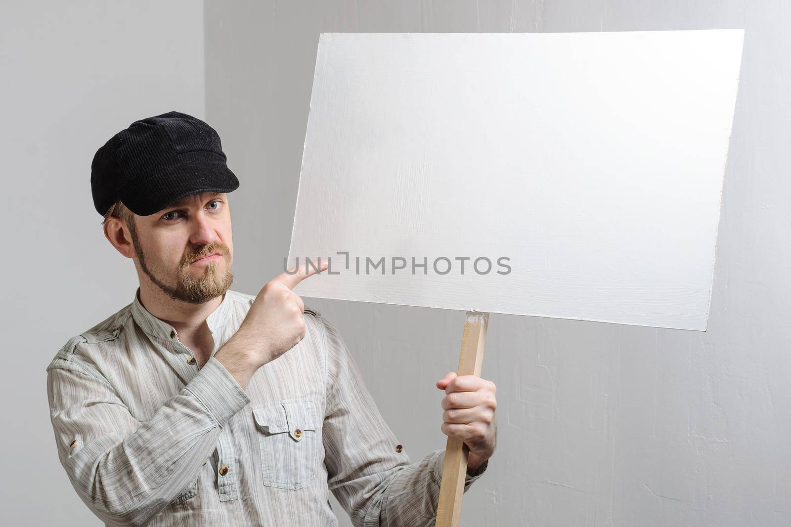 Work young man points finger on a blank banner - isolated on white.