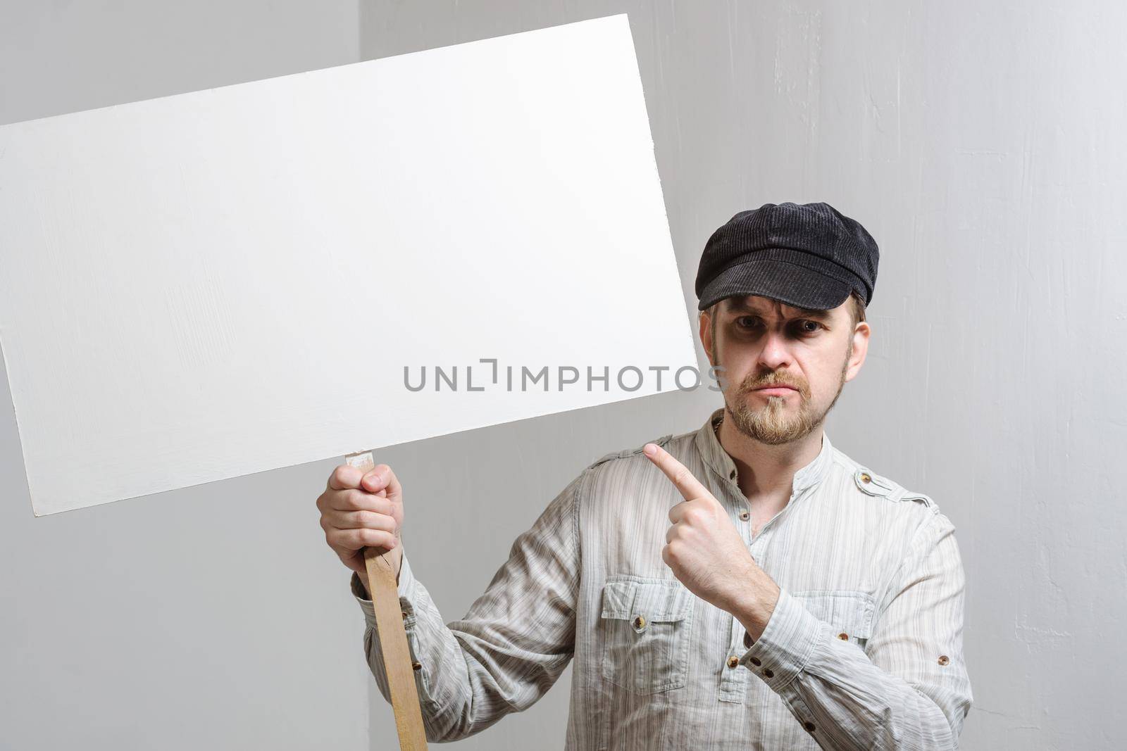 Work young man points finger on a blank banner - isolated on white.