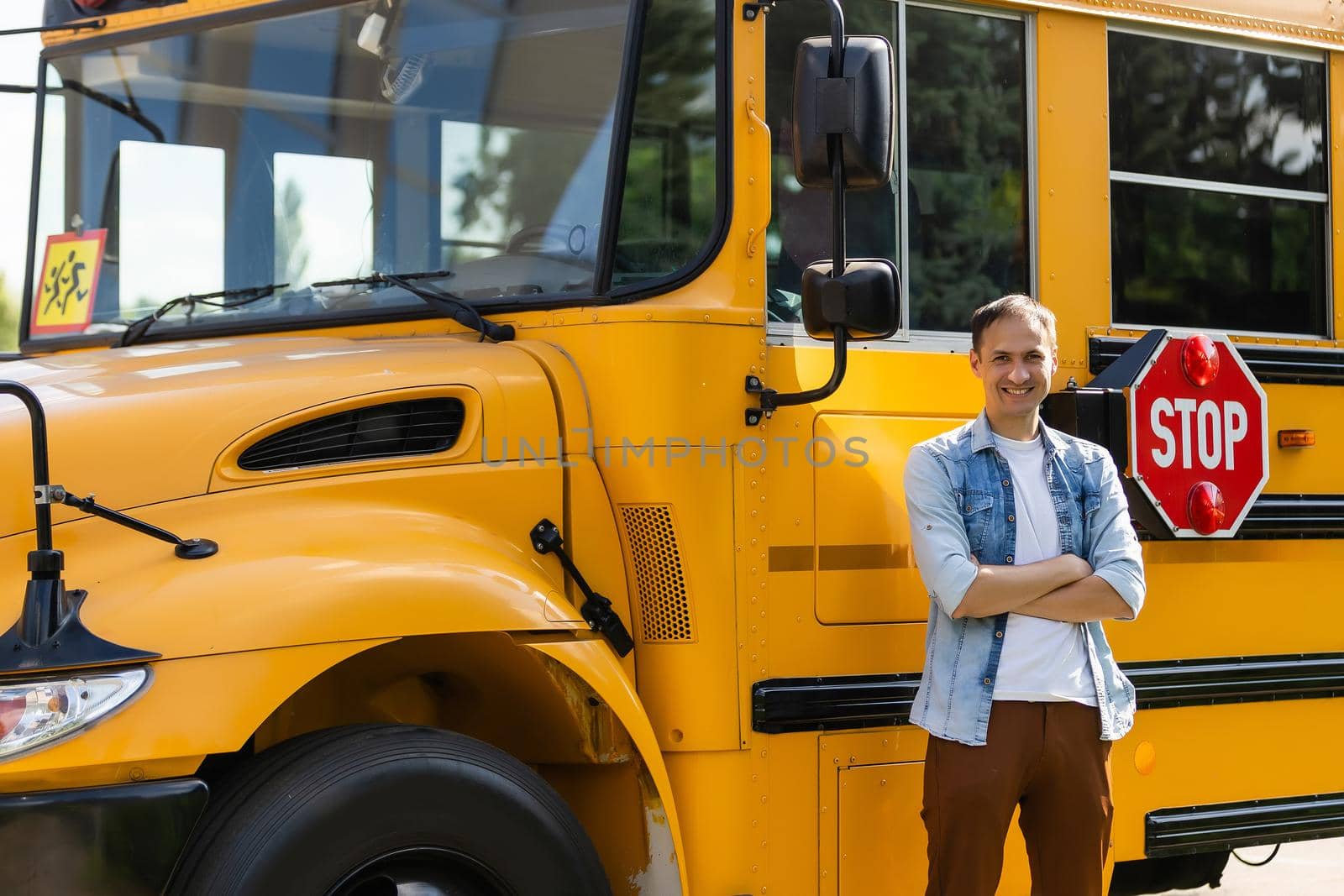 Male driver standing in front of bus