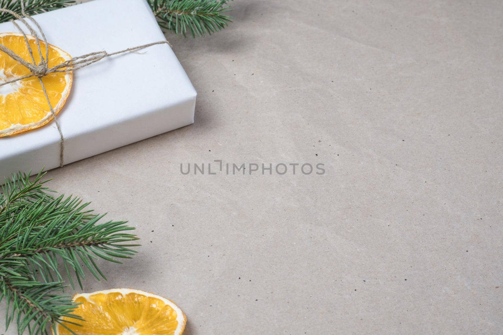New Year's composition. Light beige parchment paper background with place for text, gift boxes, dry orange oranges, fir branches. Flat lay, top view. Nordic, hygge, cozy christmas concept