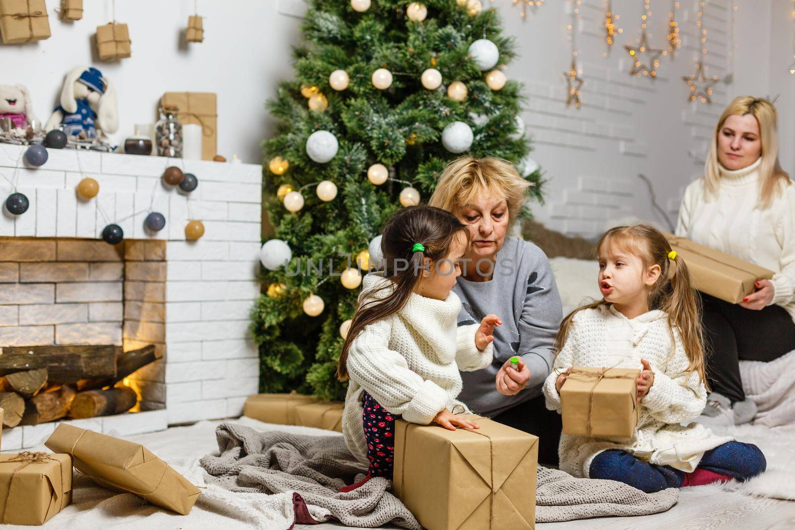 grandparents and children having fun during christmas day celebration at home with family.