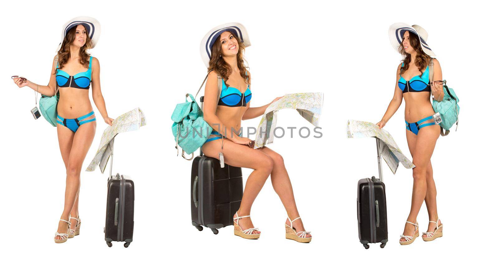 Studio image of a charming young woman in a bikini dress sitting on suitcase with map and camera isolated on white on a travel theme