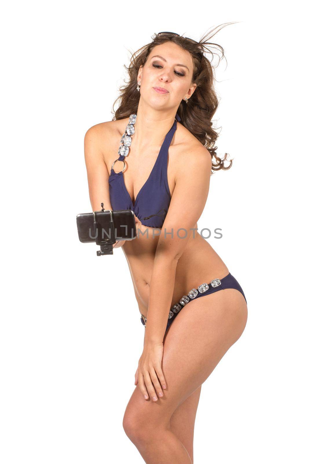 Happy young woman in blue bikini swimsuit taking selfie with smatphone