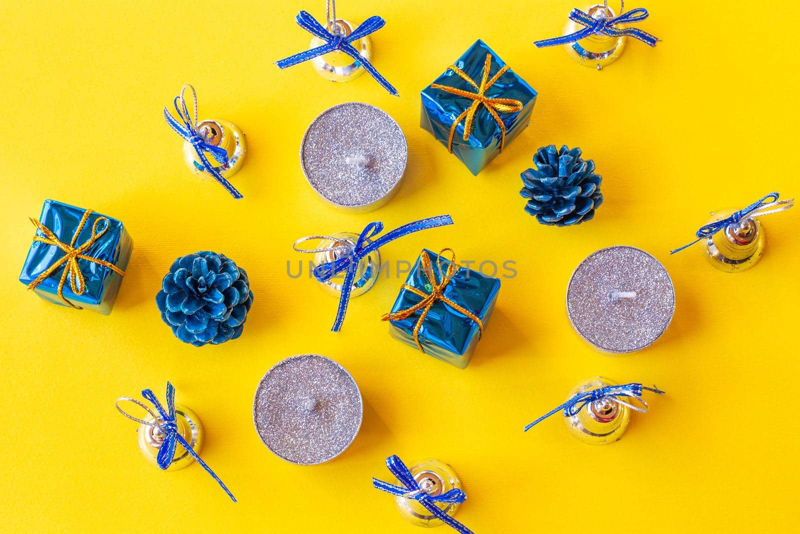 Christmas composition. Candles and Christmas decorations in blue on a yellow background.top view, copy space by levnat09