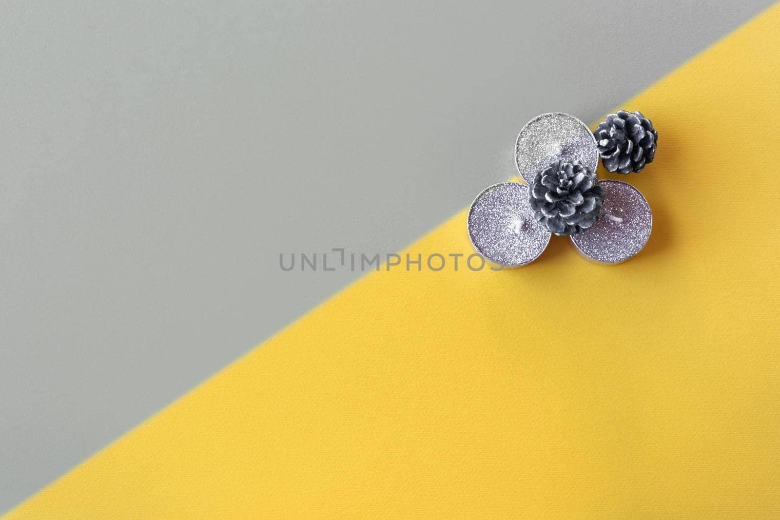 Christmas minimalist yellow background with gray gradient and candles, copy space. Trendy colors of 2021.