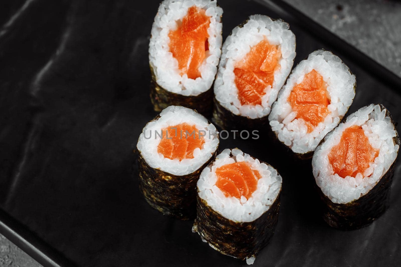 Simple maki with fresh salmon. Sushi on a gray background by UcheaD