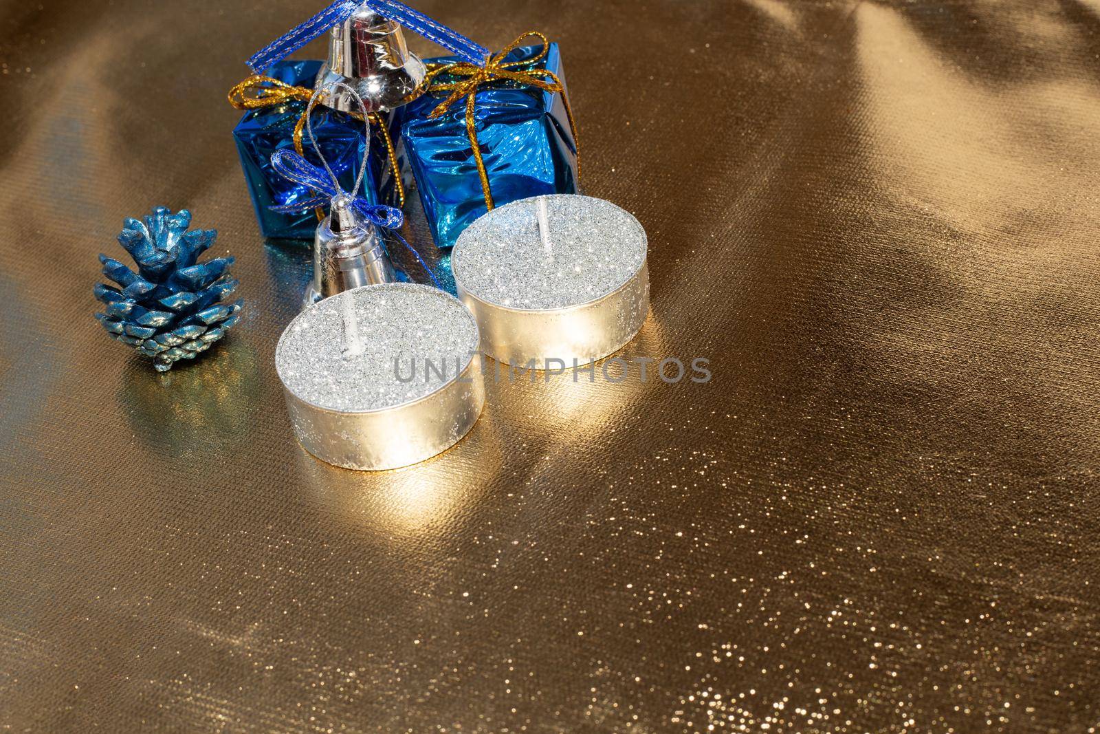 Sparkling golden background with holiday decorations and candles, copy space. New year and christmas, soft focus.