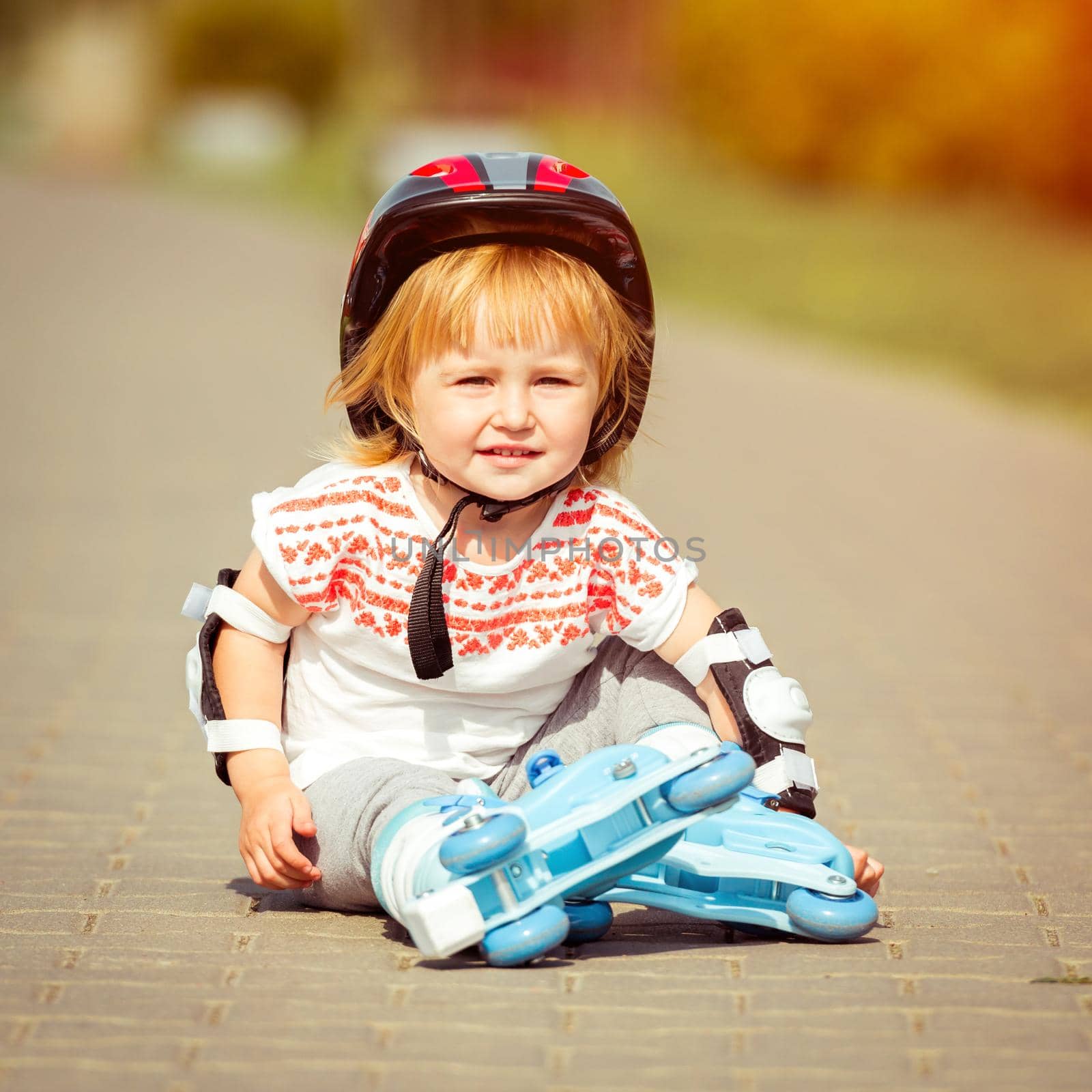 two year old girl in roller skates and a helmet by tan4ikk1