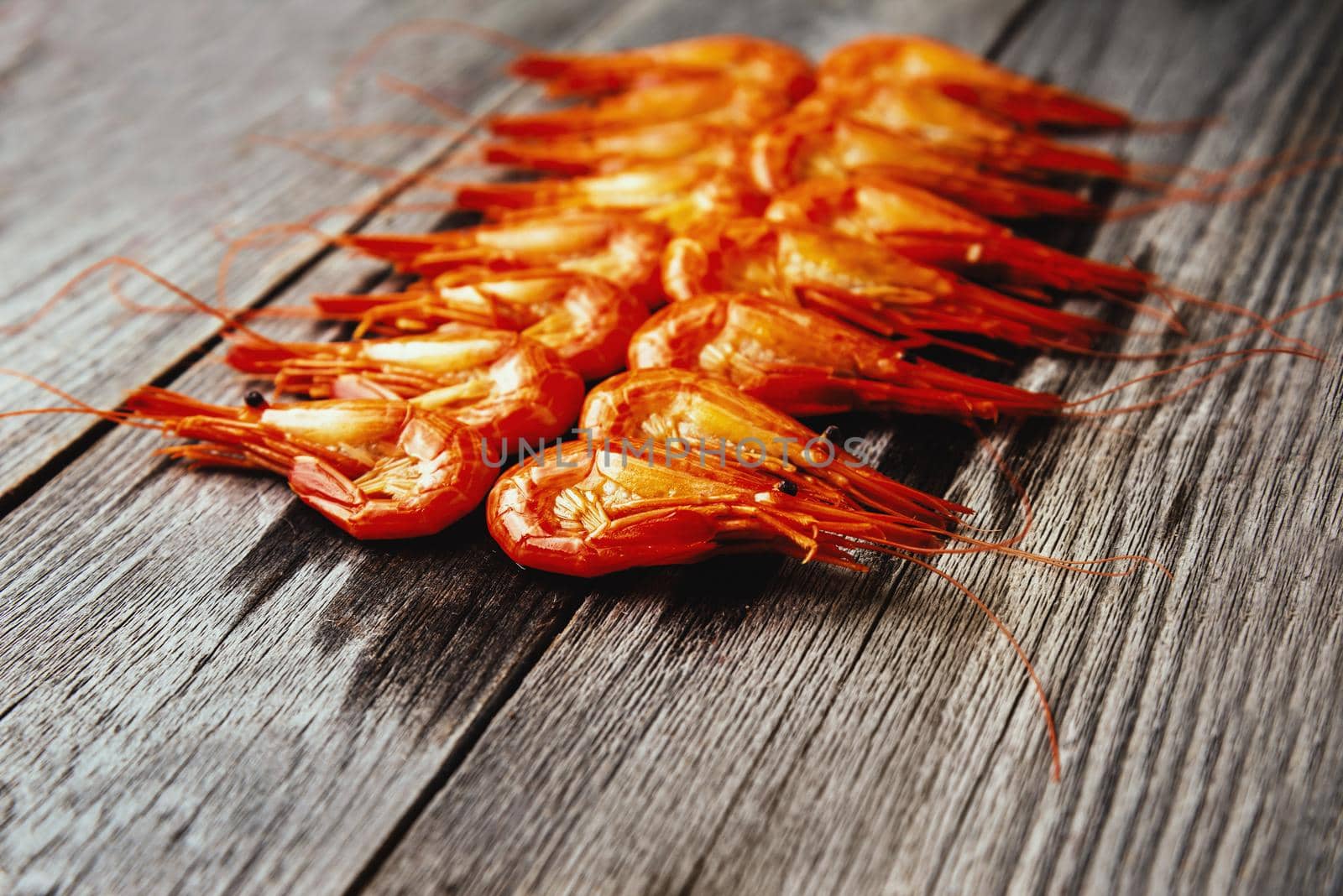 Appetizer boiled shrimps on a wooden background