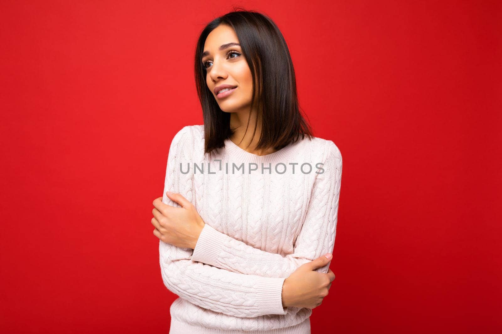 Beautiful cute nice adorable young brunet woman in stylish light knitted jersey isolated over red background wall with free space and enjoying by TRMK