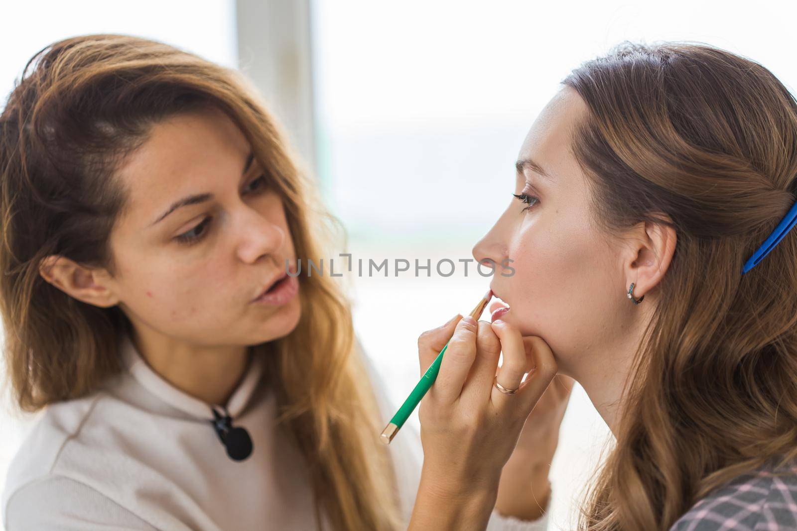 Beauty and cosmetics concept - Makeup artist doing professional make up of young woman by Satura86