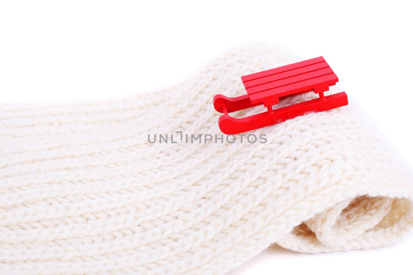red wooden sledge christmas souvenir on the white mountain made of scarf, side view