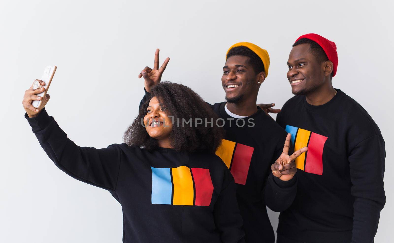 Friendship and fun concept - Group of friends afro american men and woman taking selfie in studio on white background